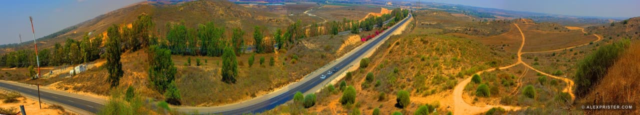 A very wide panorama of a road, terraces, hills, and a narrow line of sky